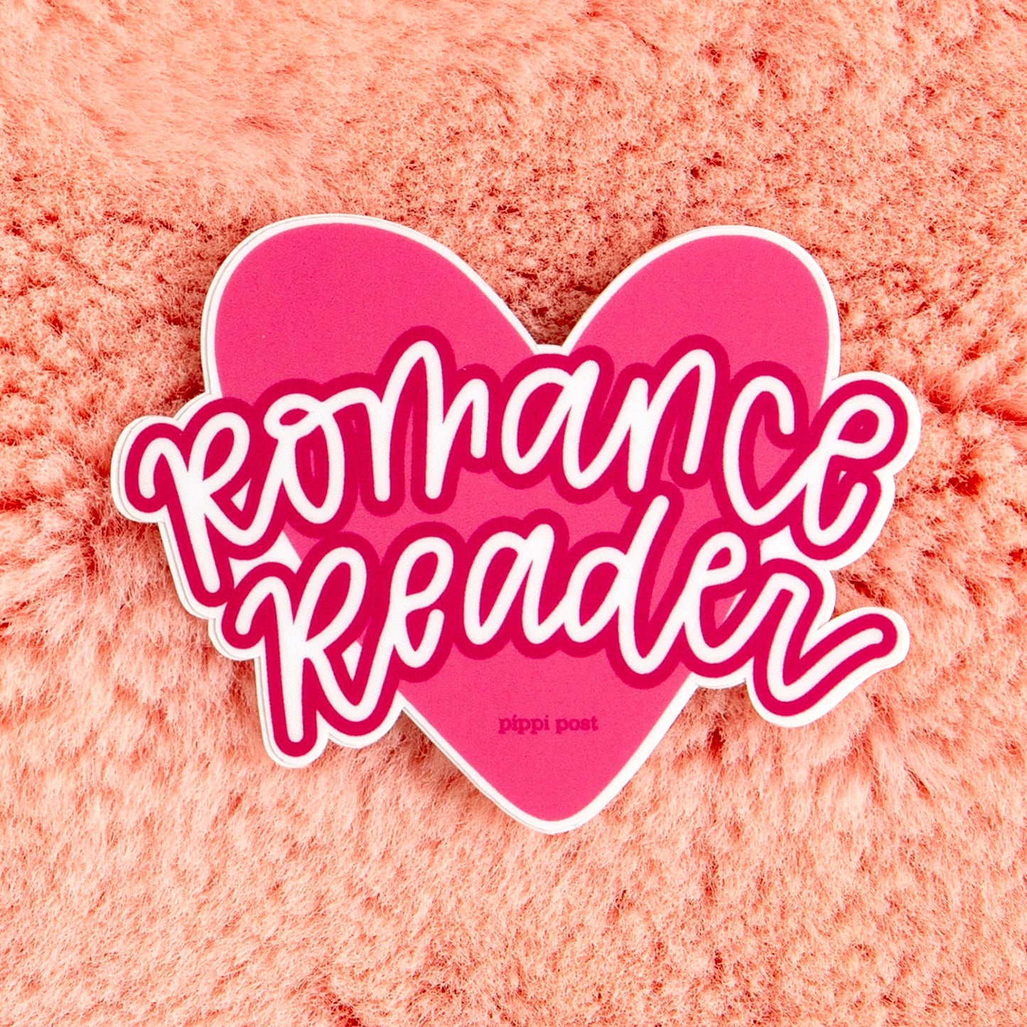 Heart-shaped 'Romance Reader' text on a pink textured background