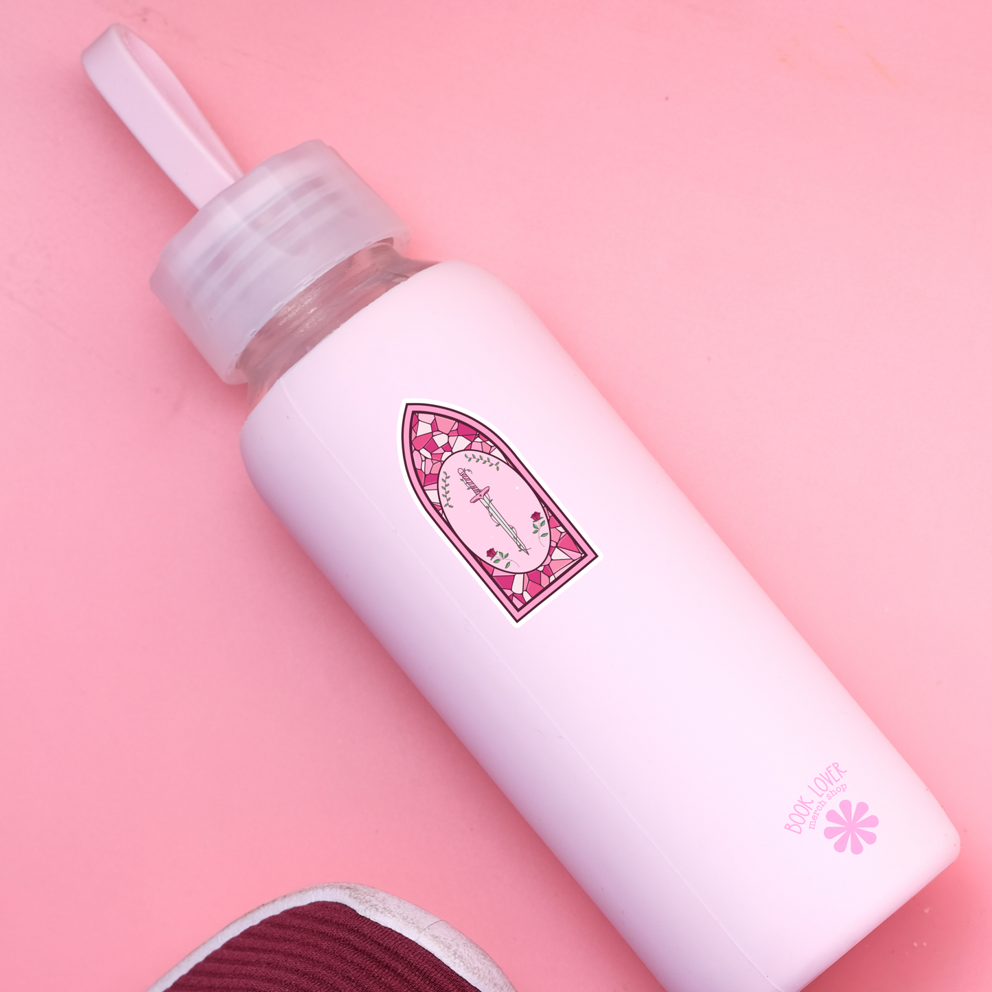White bottle with a pink label on a pink background