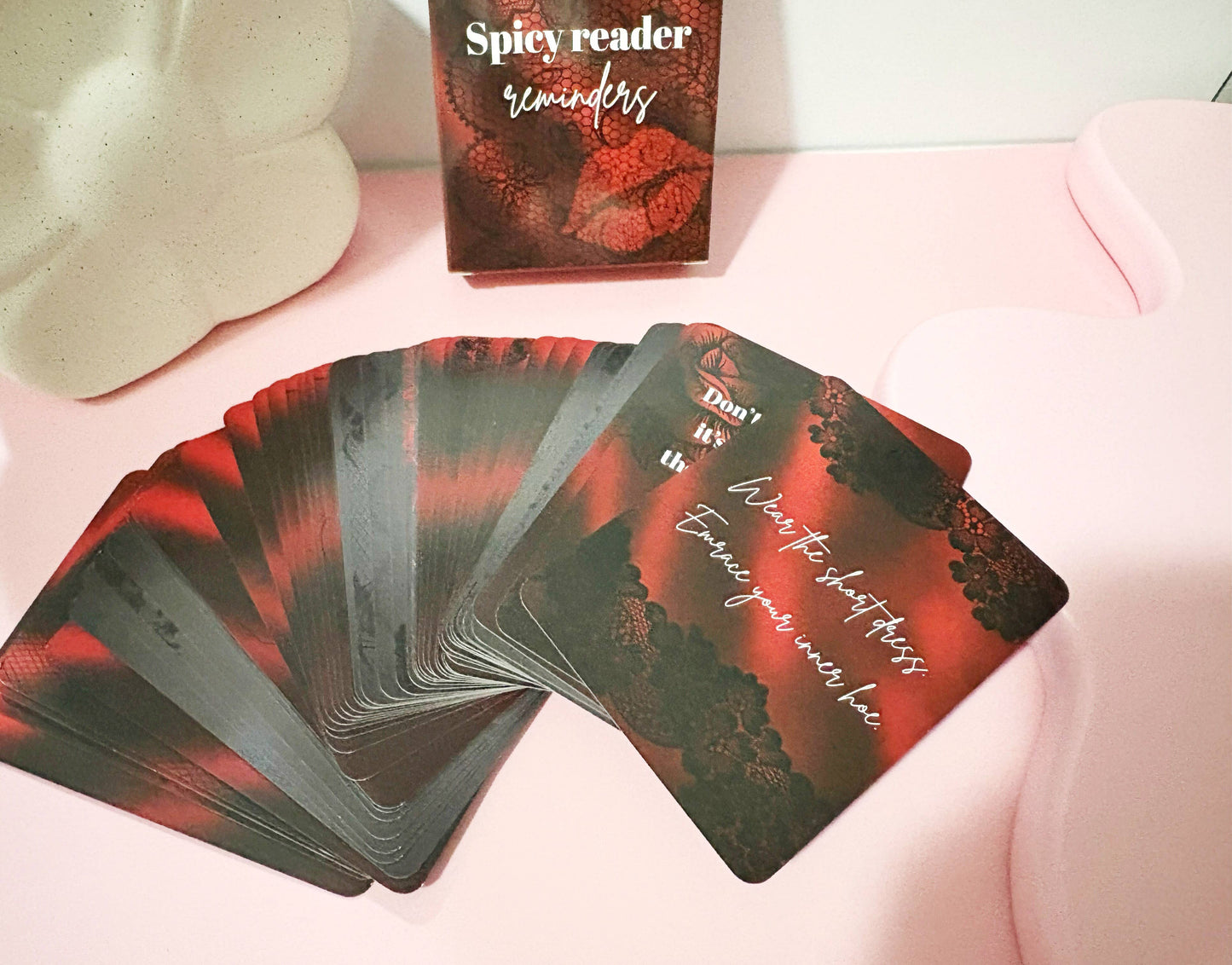 Spicy Reader tarot cards with a box on a pink surface