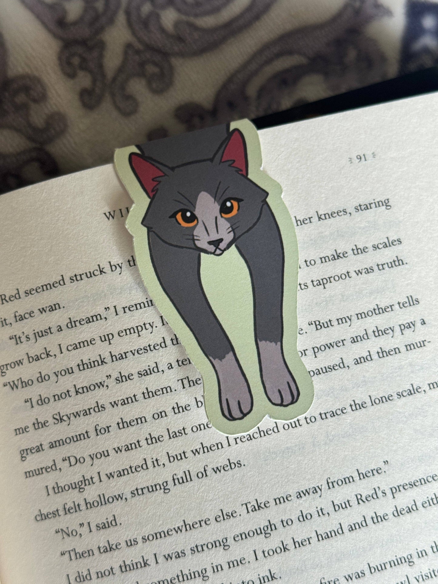 Cat-shaped bookmark on a book