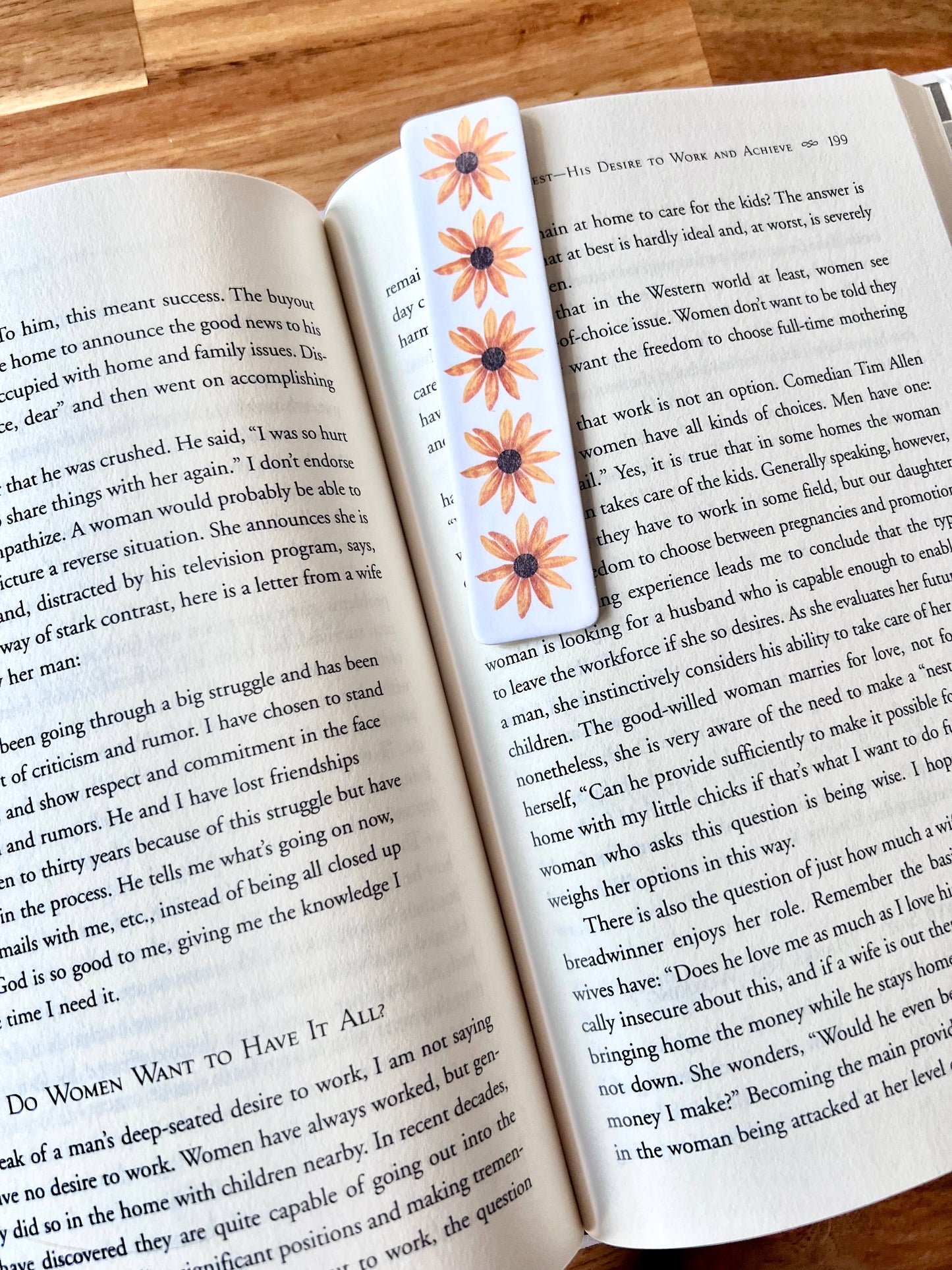 Open book with decorative flower bookmark on a wooden surface