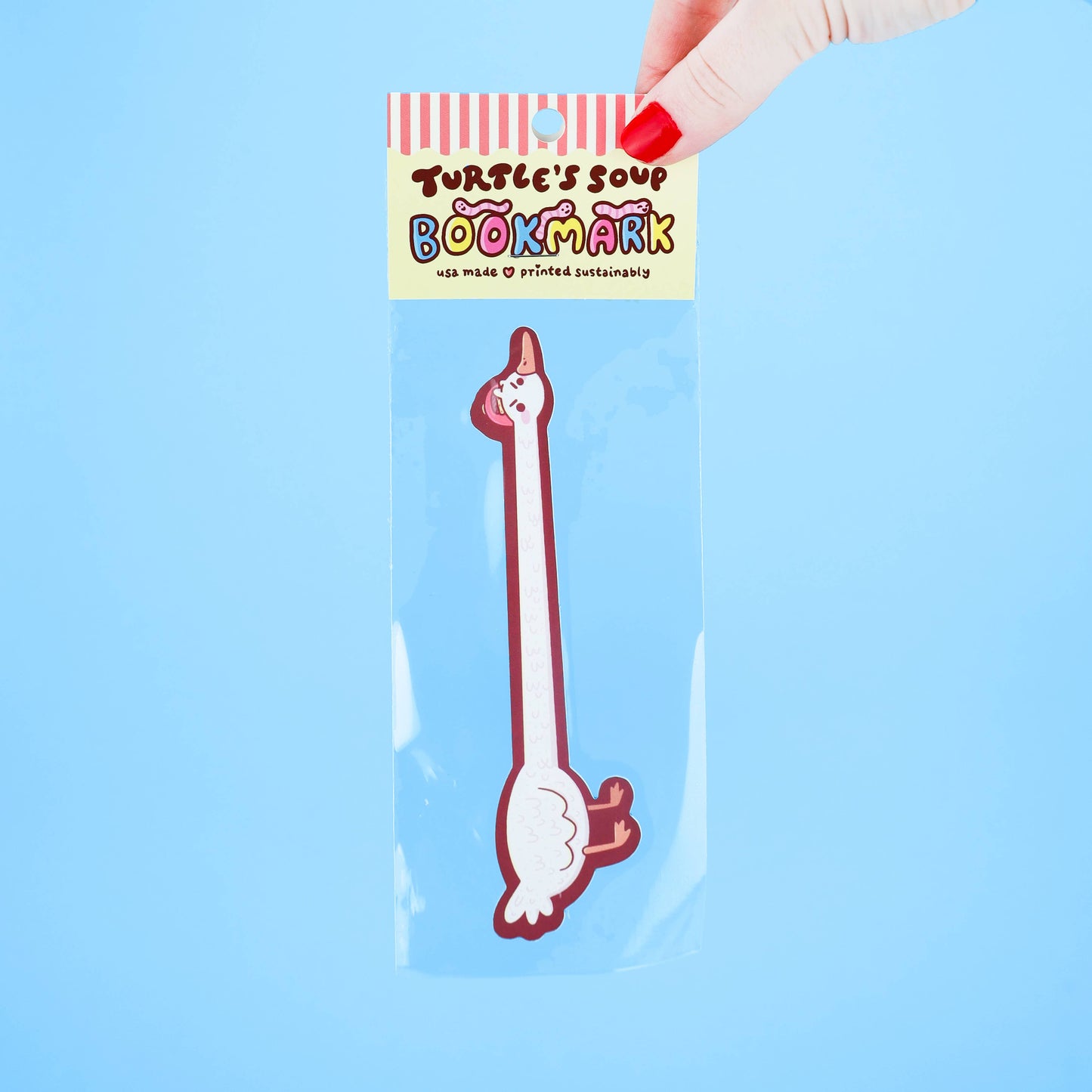 Bookmark shaped like a cartoon goose with a hand holding it against a blue background