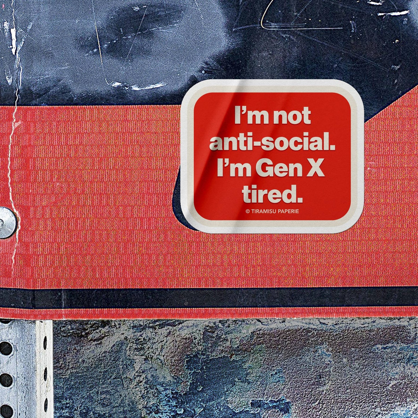 Red notebook with a white label reading 'I'm not anti-social. I'm Gen X tired.' on a textured background.