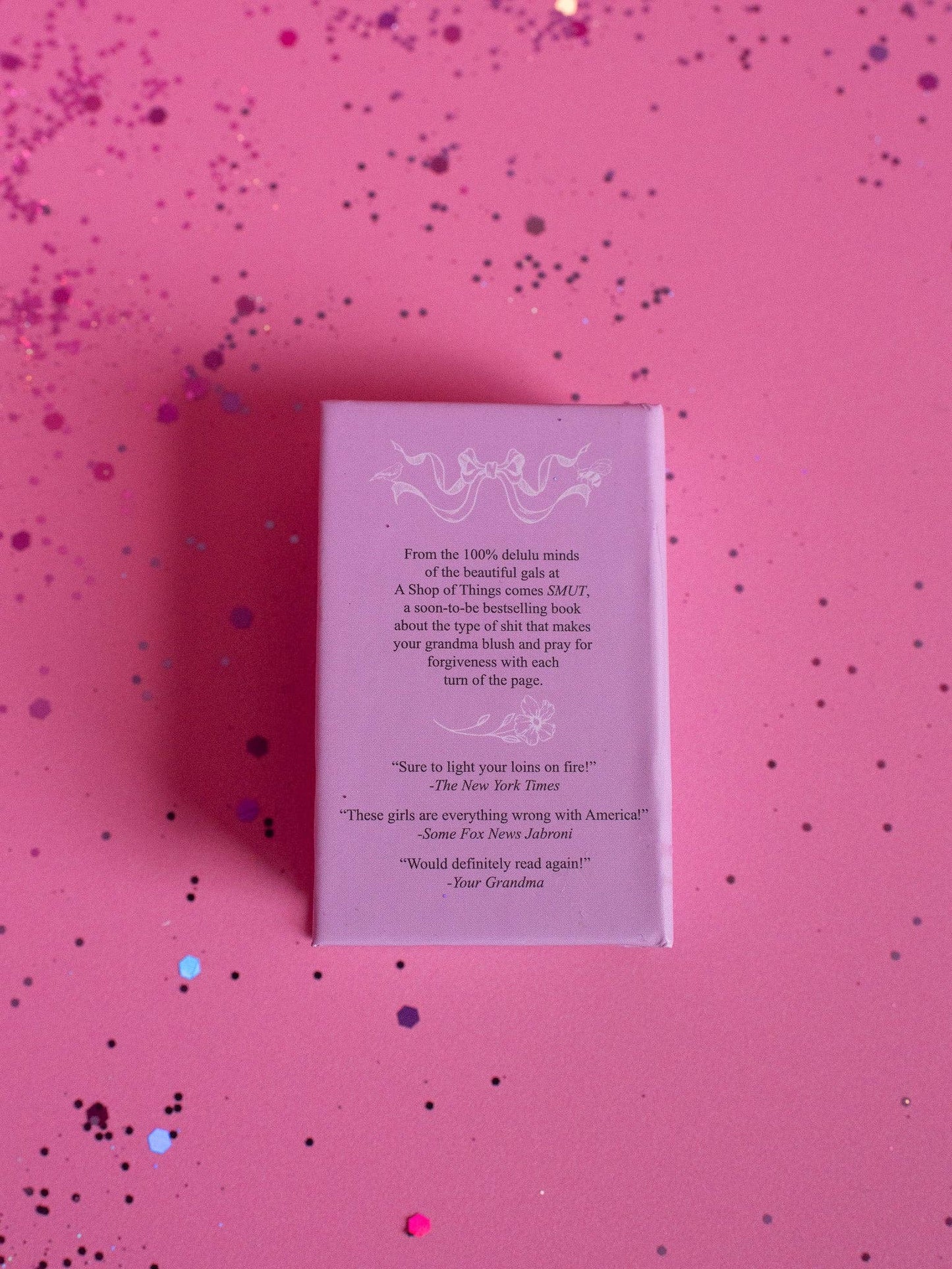 Pink book with text on a pink background with confetti