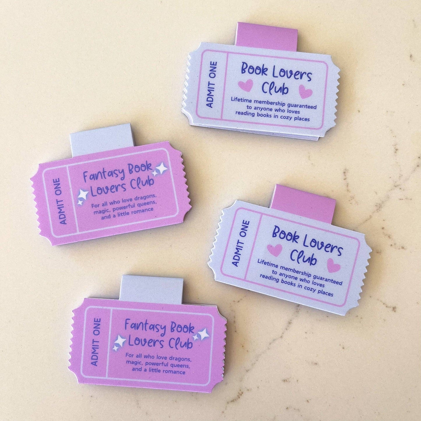 Four pink 'Book Lovers Club' tickets on a beige background