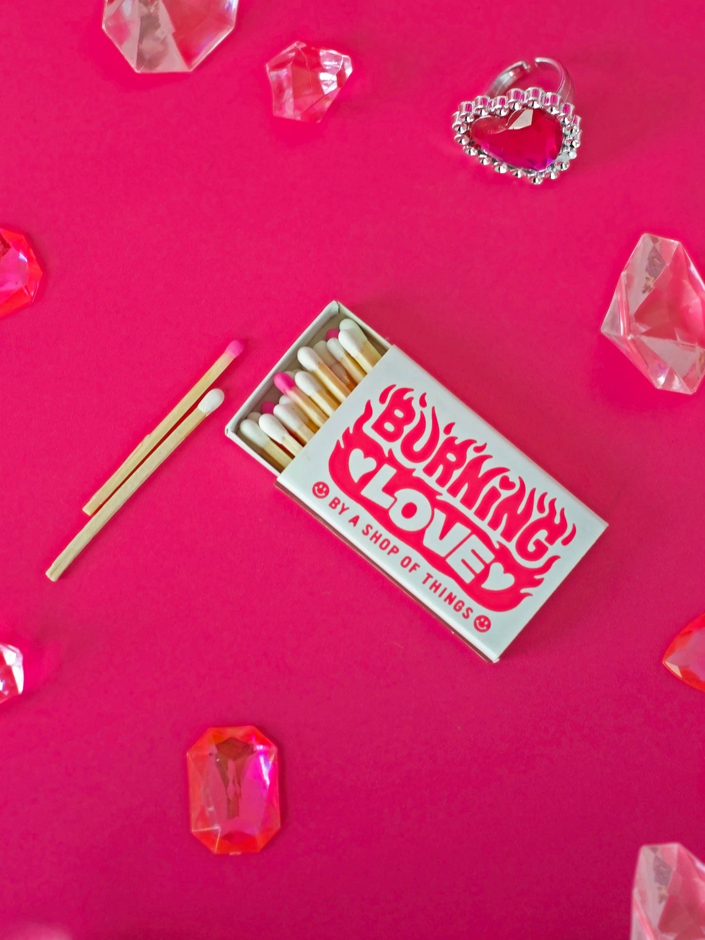 Matchbox with matches on a pink background with decorative elements