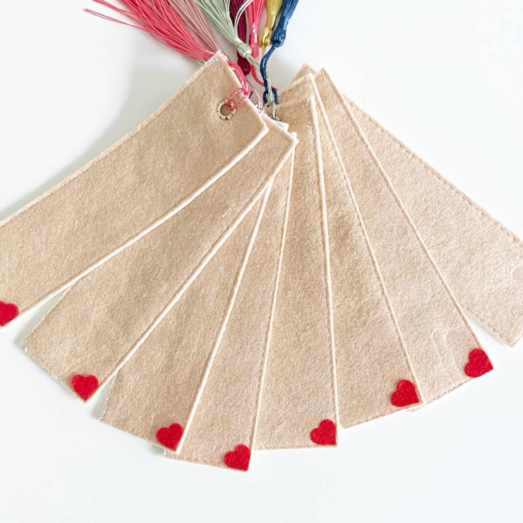 Beige felt bookmarks with red heart shapes on a white background