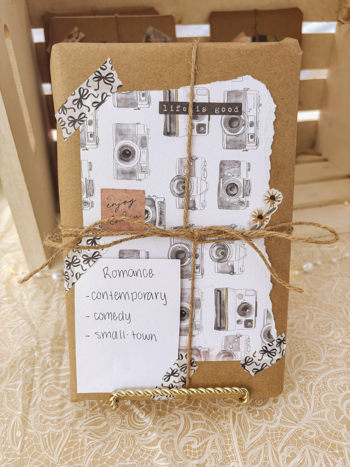 Two books wrapped in brown paper with a patterned cover and string, on a textured surface.