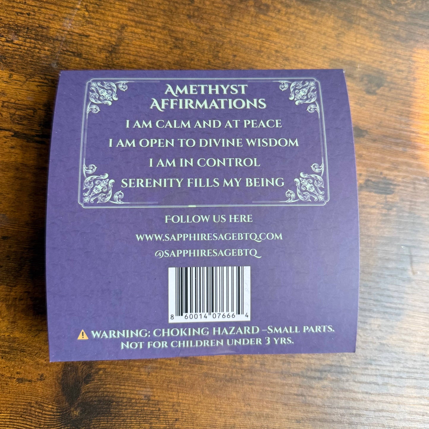 Purple card with affirmations on a wooden surface