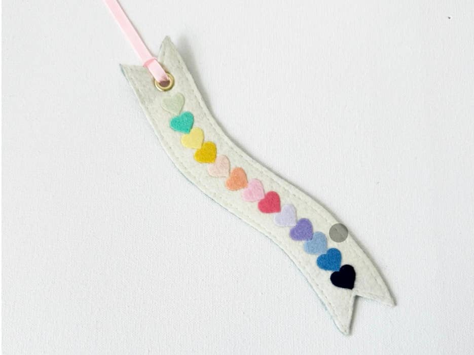 Decorative ribbon-shaped bookmark with colorful heart shapes on a white background