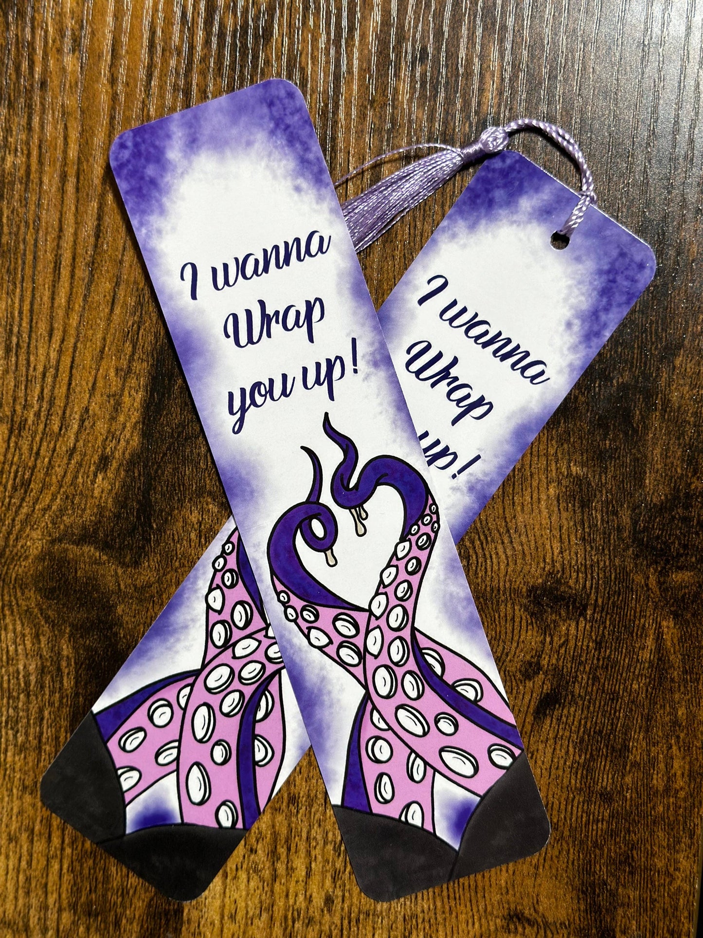 Pair of socks with peacock design and text on a wooden surface
