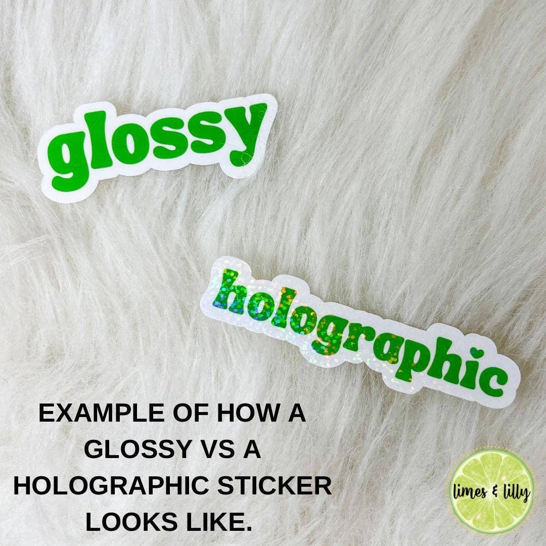 Two stickers labeled 'glossy' and 'holographic' on a textured surface with text explaining the difference.