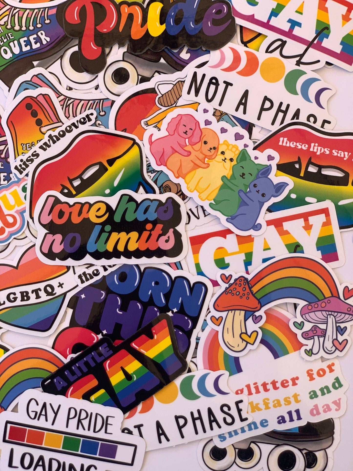 Collection of colorful stickers with pride-themed designs on a white background