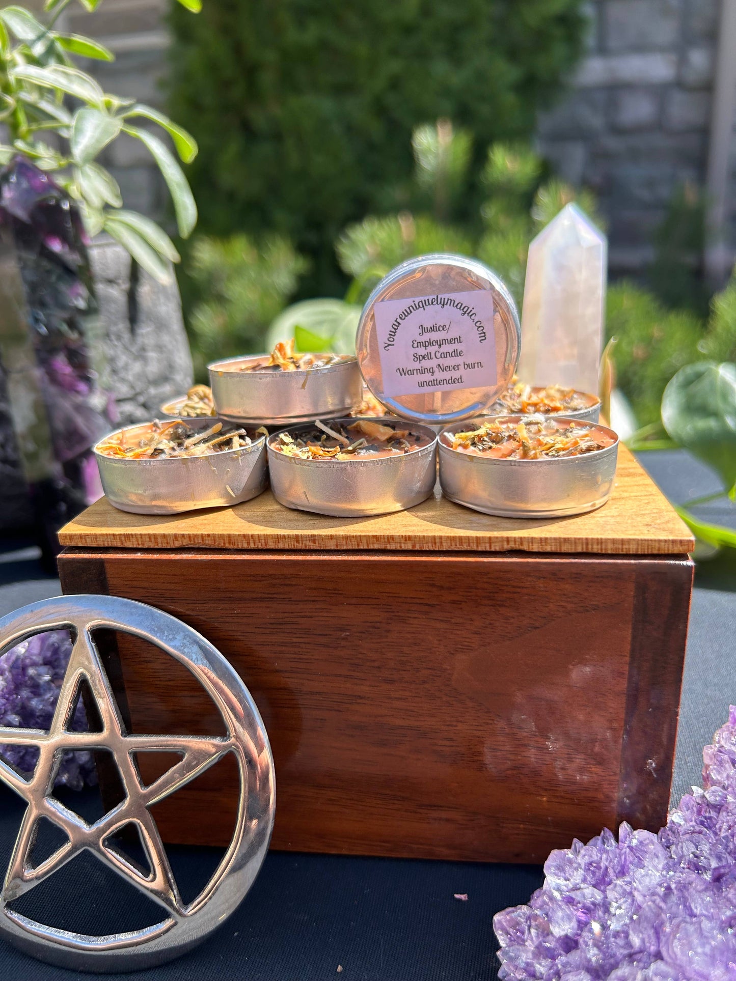 Wooden box with small candles, surrounded by crystals and a pentacle symbol.