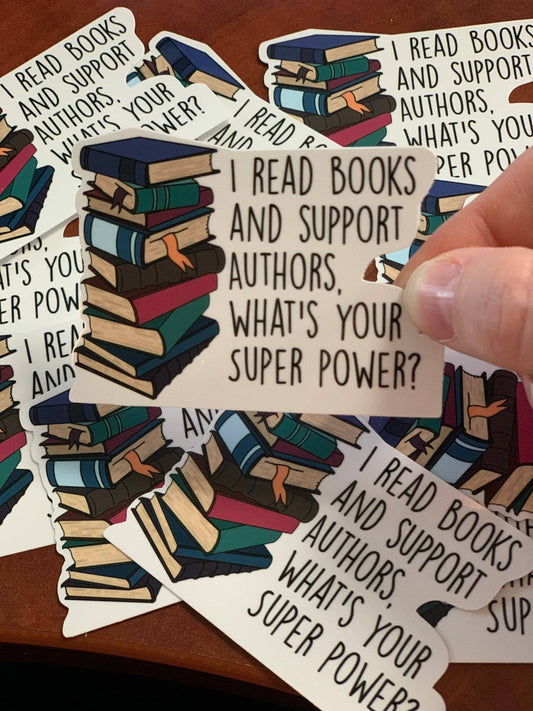 Sticker with book illustration and text 'I read books and support authors, what's your super power?' held by a hand.