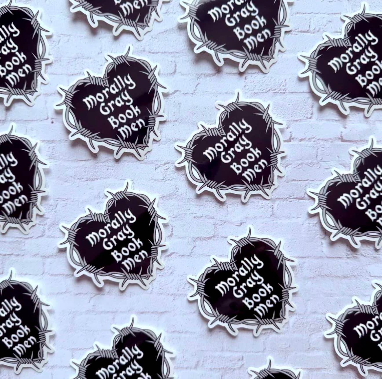 Stickers with 'Morally Gray Book Men' text on a white background