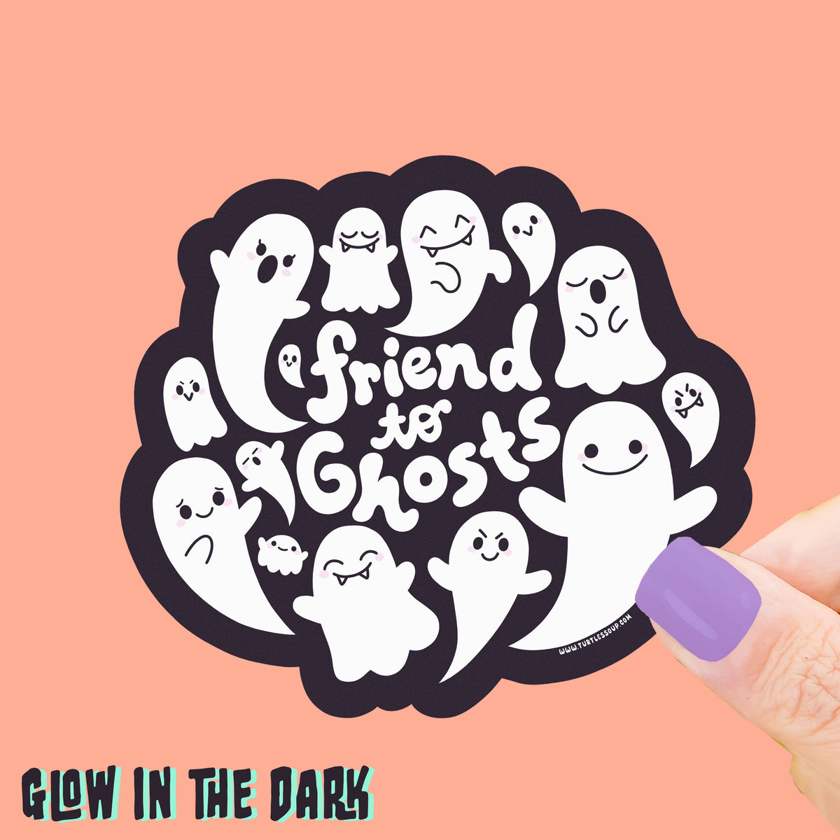 Sticker with cartoon ghosts and text 'Friend to Ghosts' held by a hand on a pink background