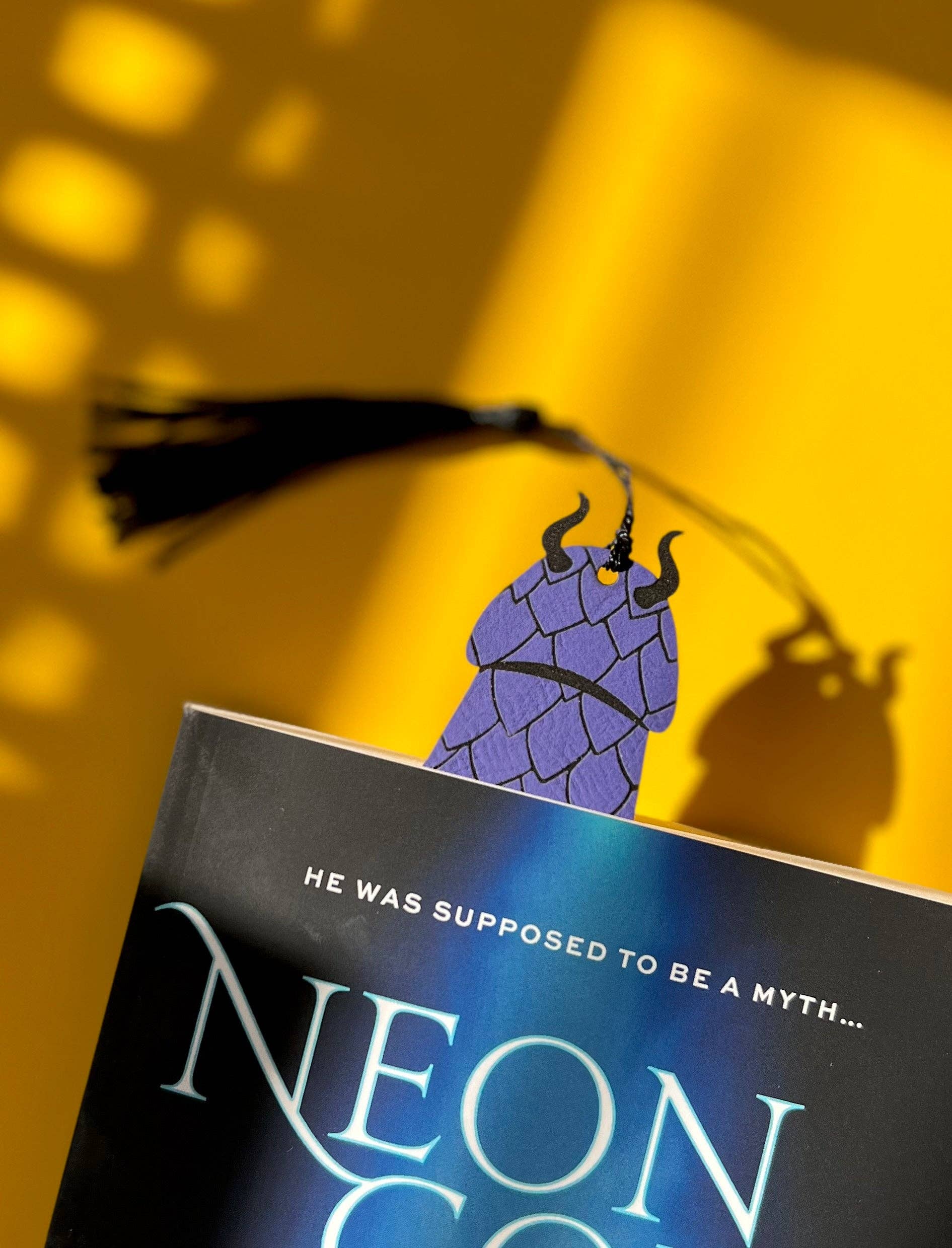 Book titled 'Neon God' with a character illustration on a yellow background