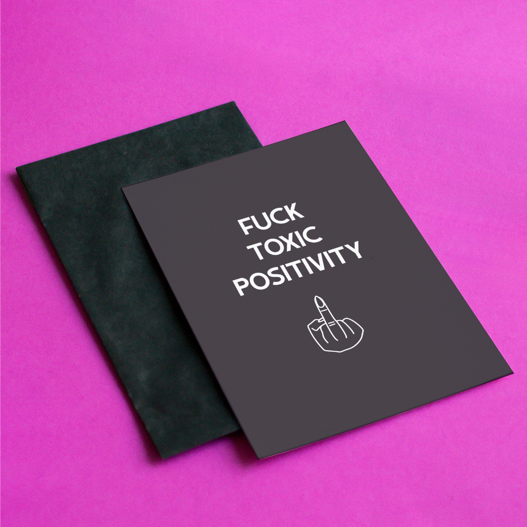 Notebook with 'Fuck Toxic Positivity' text on a pink background