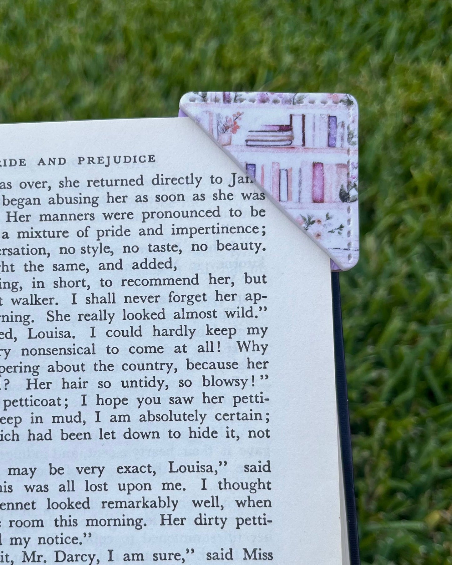 Book with a decorative corner bookmark on grass