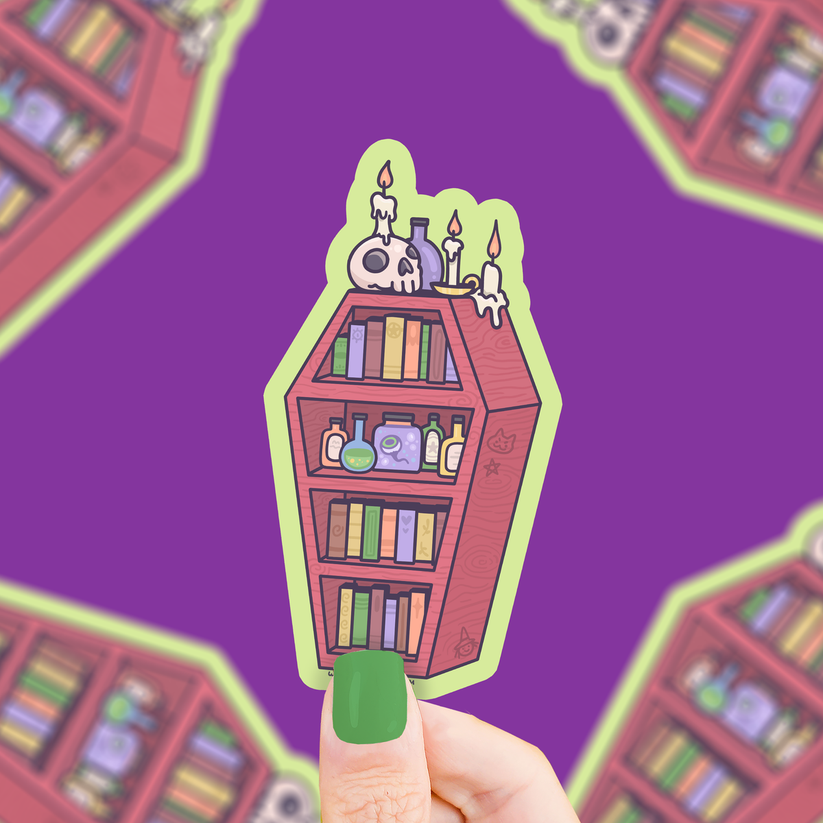 Hand holding a sticker of a bookshelf with books and candles against a purple background
