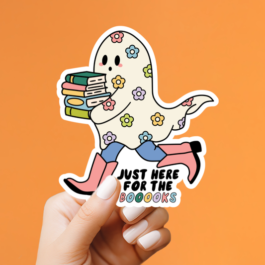 Sticker of a ghost holding books with text 'Just here for the boookss' held by a hand on an orange background
