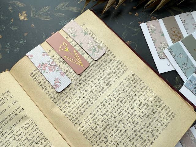 Open book with decorative bookmarks on a dark surface