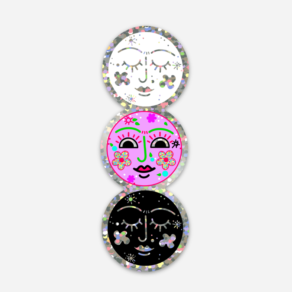 Three circular decorative stickers stacked vertically on a light gray background. The top sticker is white with a glittery border and a minimalist face with closed eyes and floral accents.