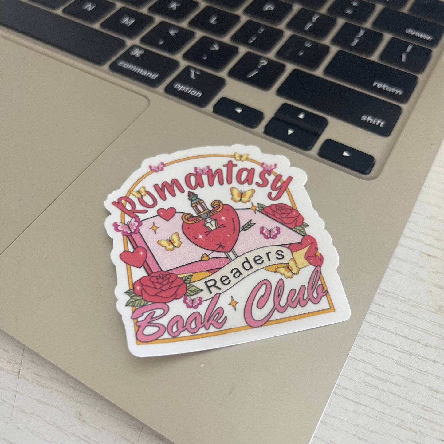 Sticker for 'Romantasy Readers Book Club' on a laptop keyboard