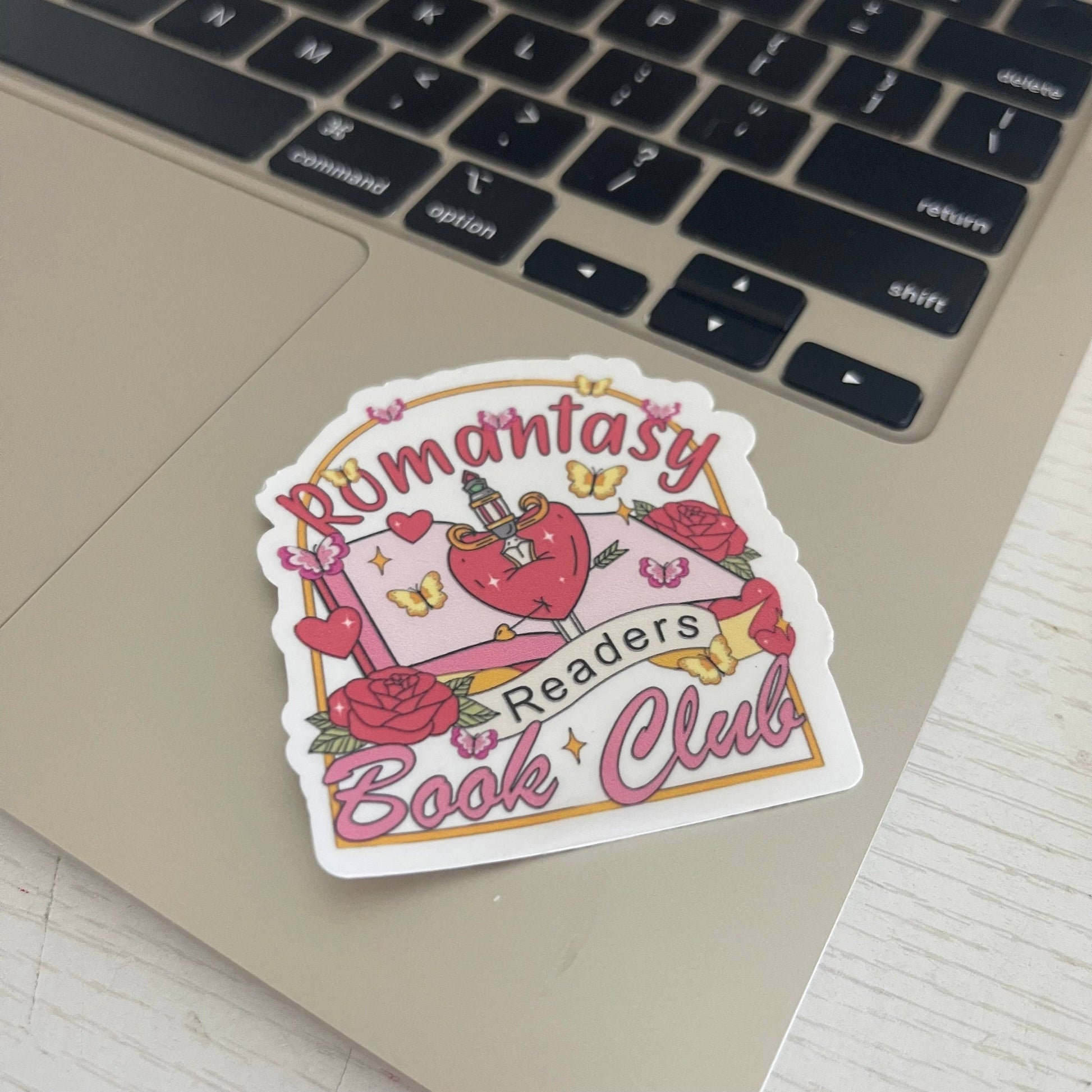 Sticker for 'Romantasy Readers Book Club' on a laptop keyboard