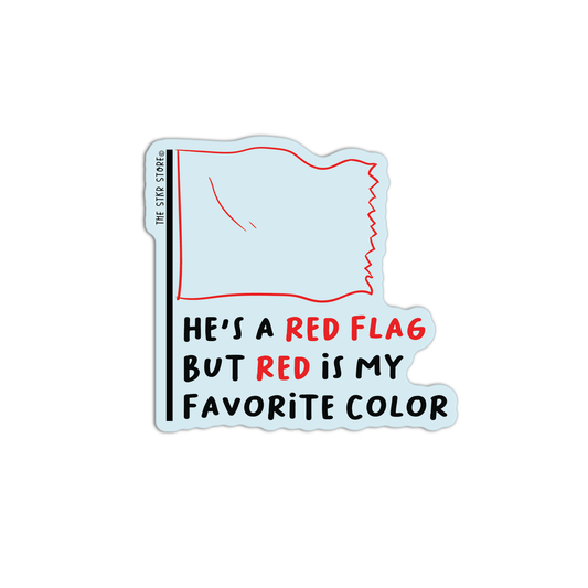 A die-cut sticker featuring a light blue flag with a red border and the text 'HE'S A RED FLAG BUT RED IS MY FAVORITE COLOR' in black and red lettering, shown on a plain white background.