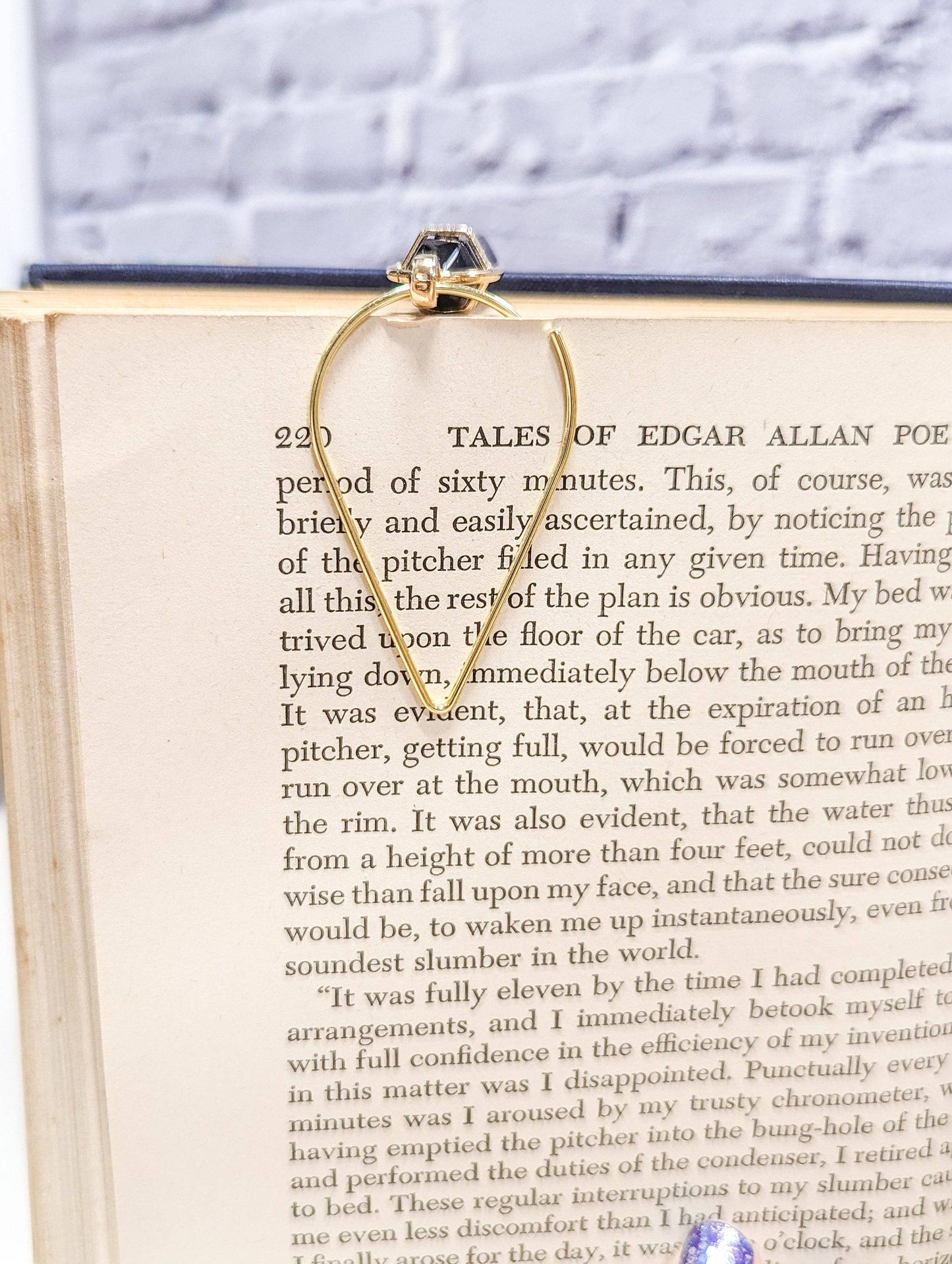 Gold hoop bookmark on an open book with a white background