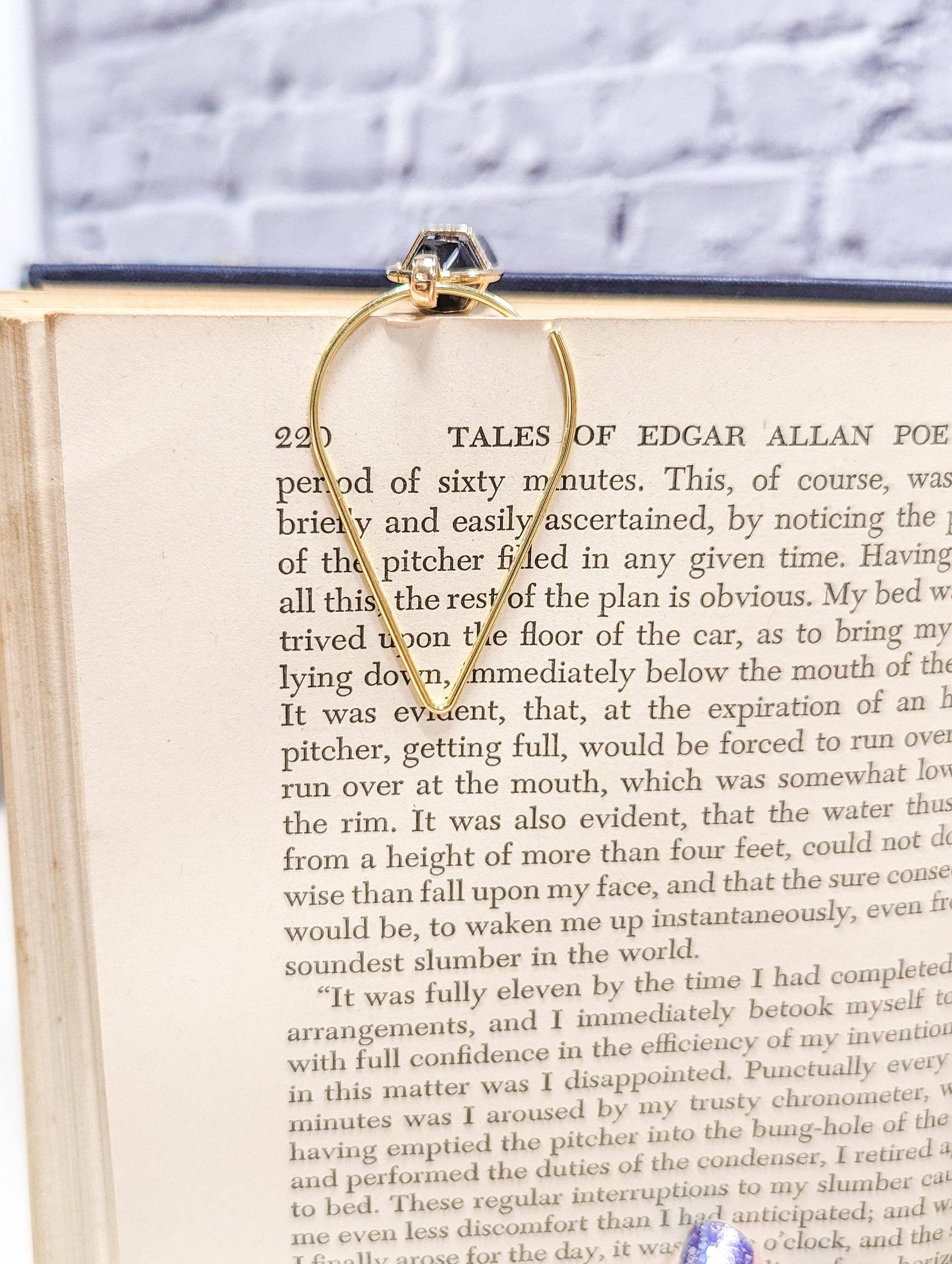 Gold hoop bookmark on an open book with a white background
