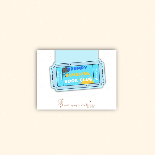 A square white card featuring a stylized blue and yellow ticket graphic that reads 'Grumpy Sunshine Book Club,' centered on a light beige background.