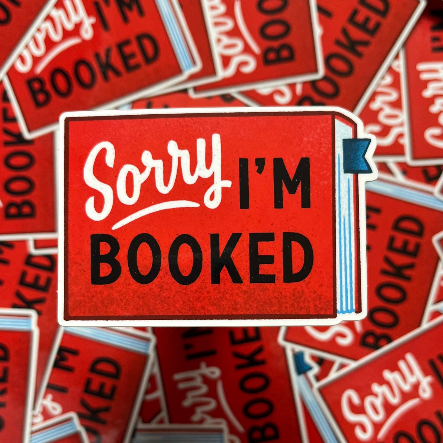 Red 'Sorry I'm Booked' stickers with a blue flag on a red background