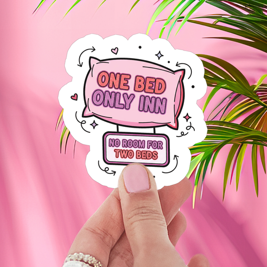 Sticker with 'One Bed Only Inn' text held against a pink background with green leaves.