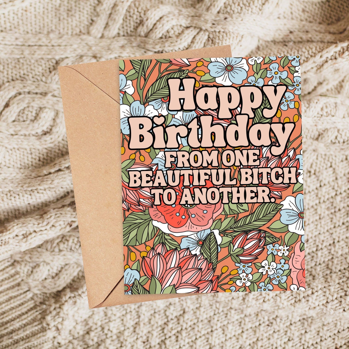 Birthday card with floral design and humorous text on a textured surface