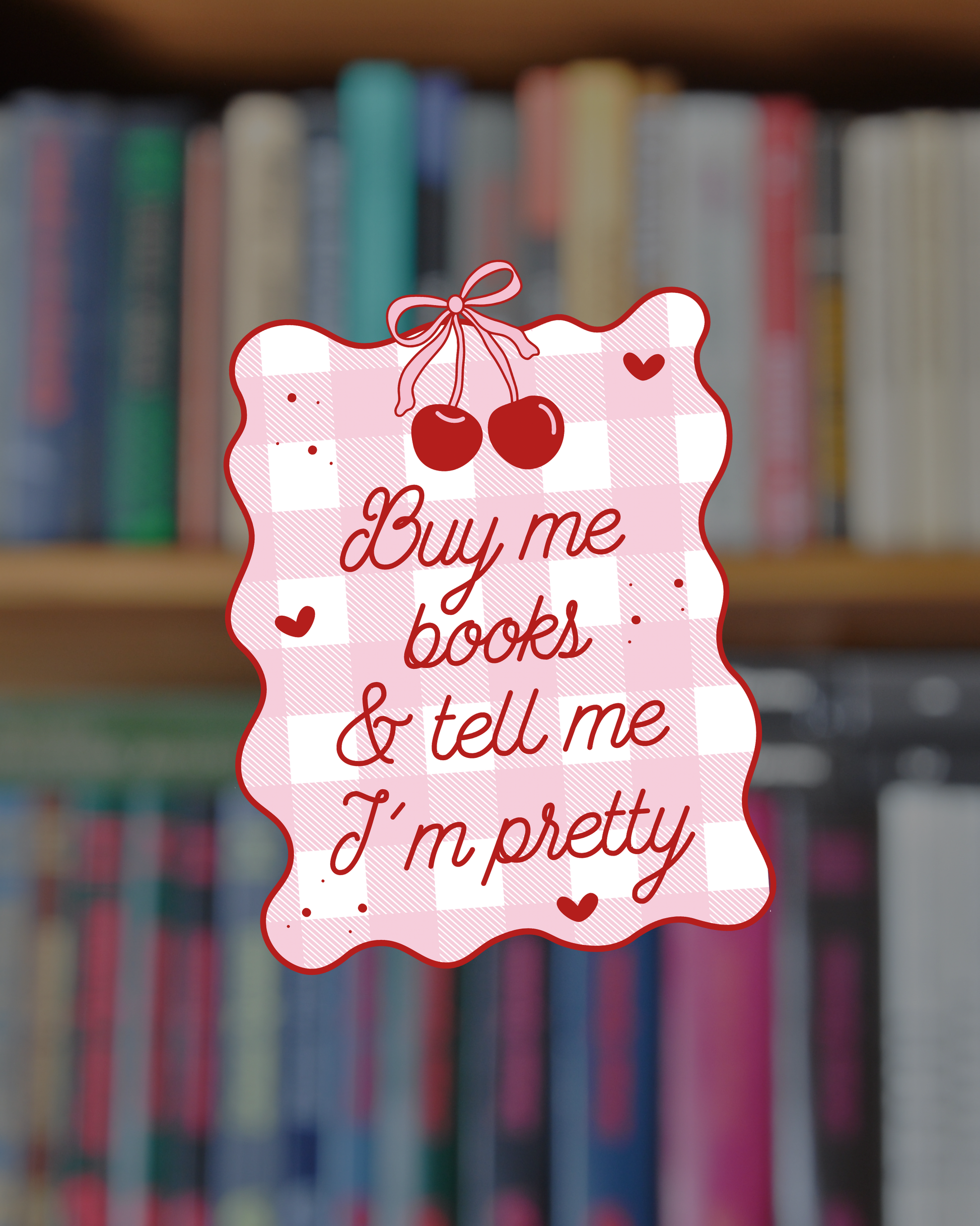 Decorative sign with 'Buy me books & tell me I'm pretty' text on a bookshelf background