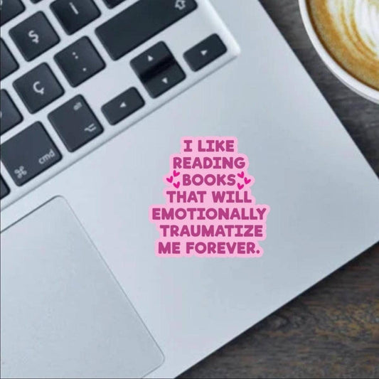 Laptop with a pink text sticker on the keyboard, next to a cup of coffee.