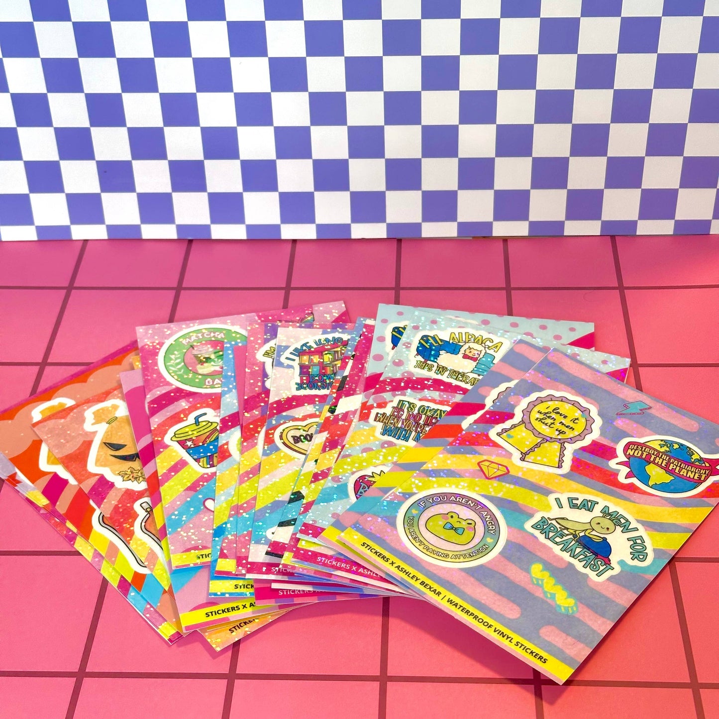 Colorful sticker sheets on a pink and blue checkered background