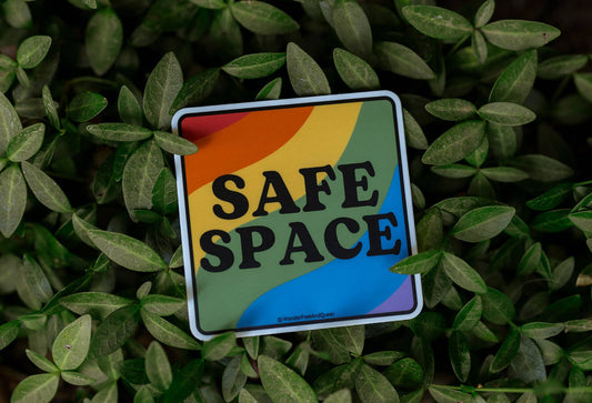 Rainbow-colored 'Safe Space' sticker on green leaves