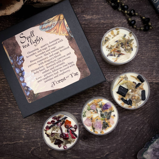 Set of spell-themed tea light candles with decorative packaging on a wooden surface.