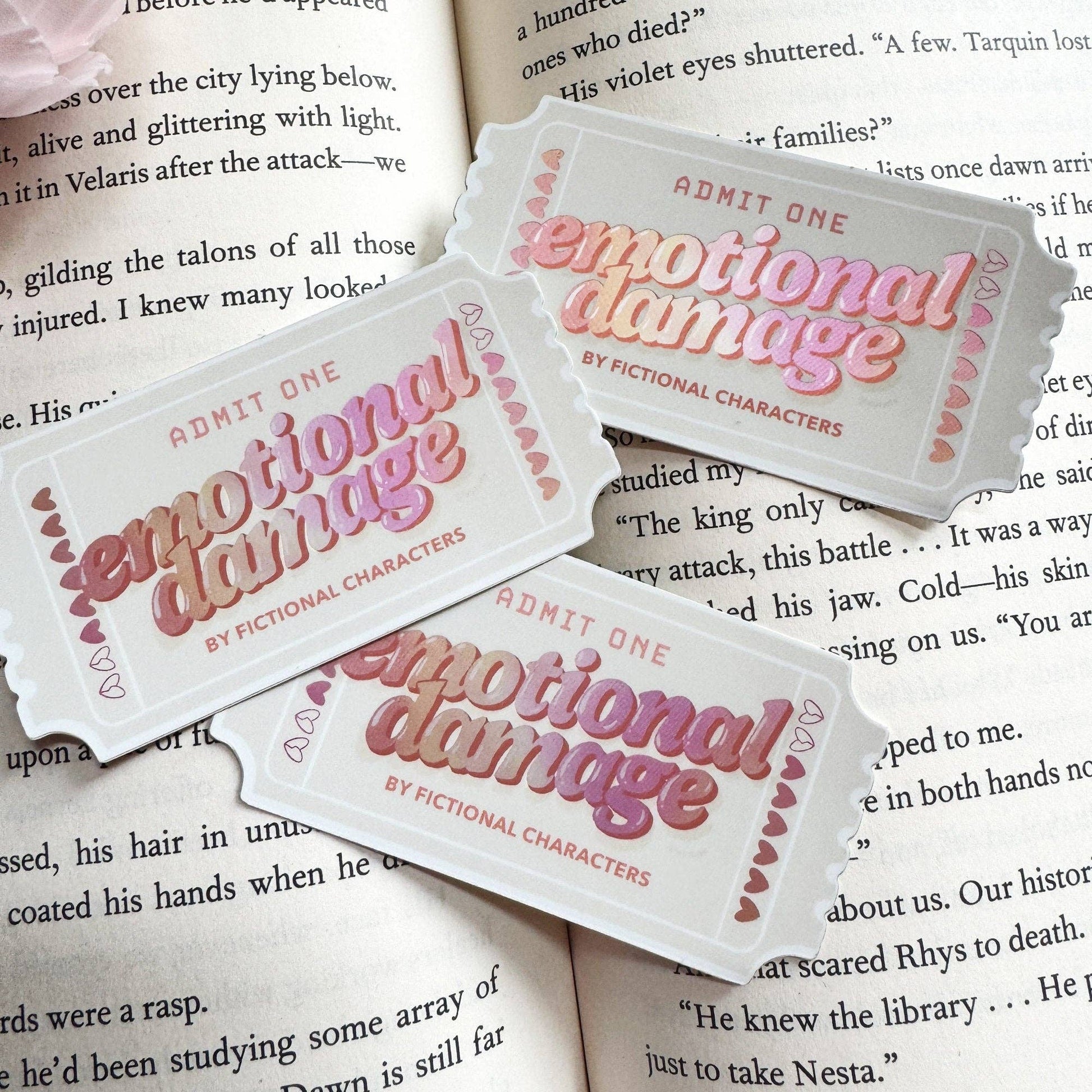 Tickets labeled 'Emotional Damage by Fictional Characters' on top of a book