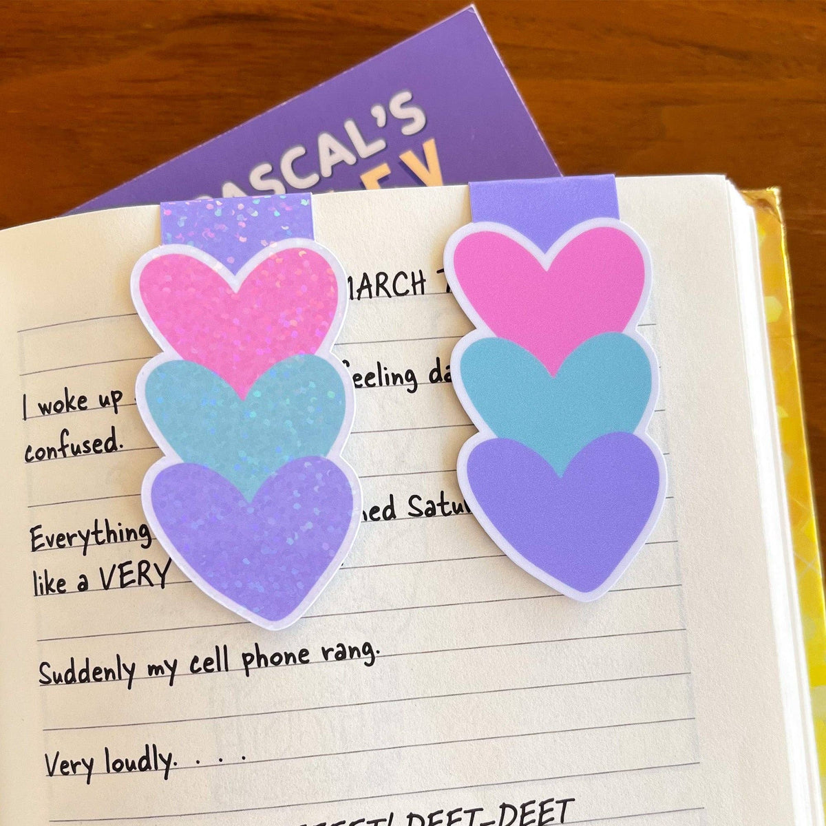 Colorful heart-shaped bookmarks on a notebook page with text.