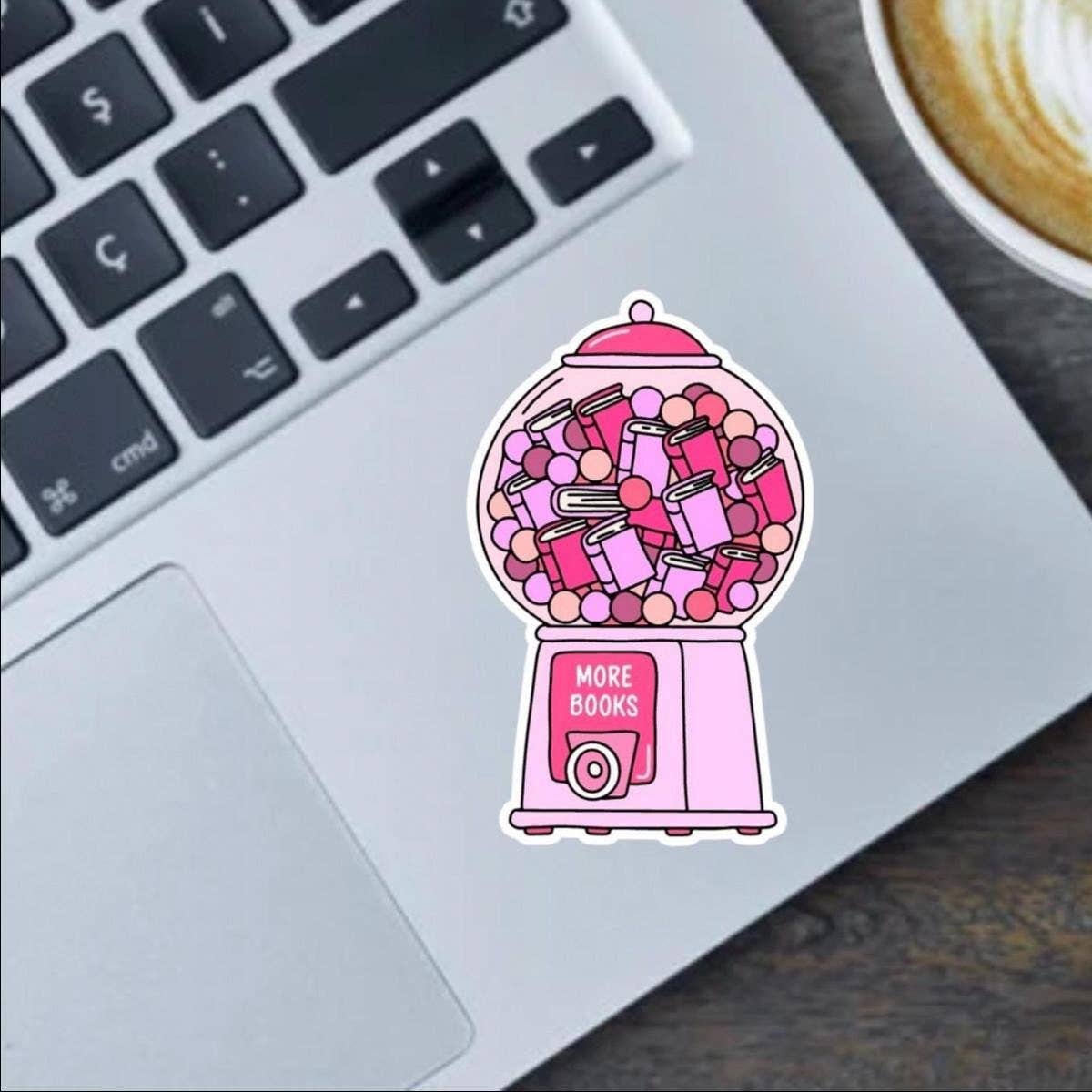 Pink gumball machine sticker with 'More Books' text on a laptop