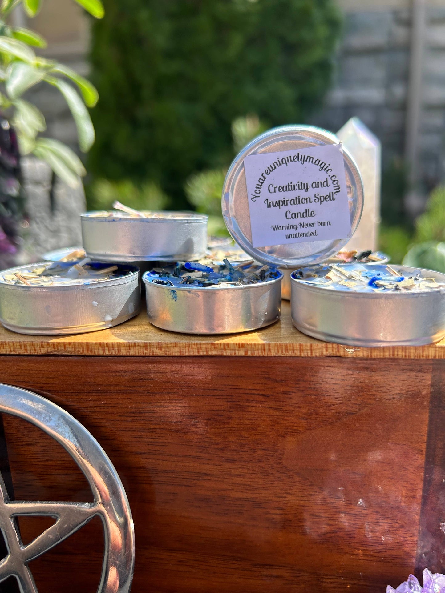 Candle tins with labels on a wooden surface outdoors