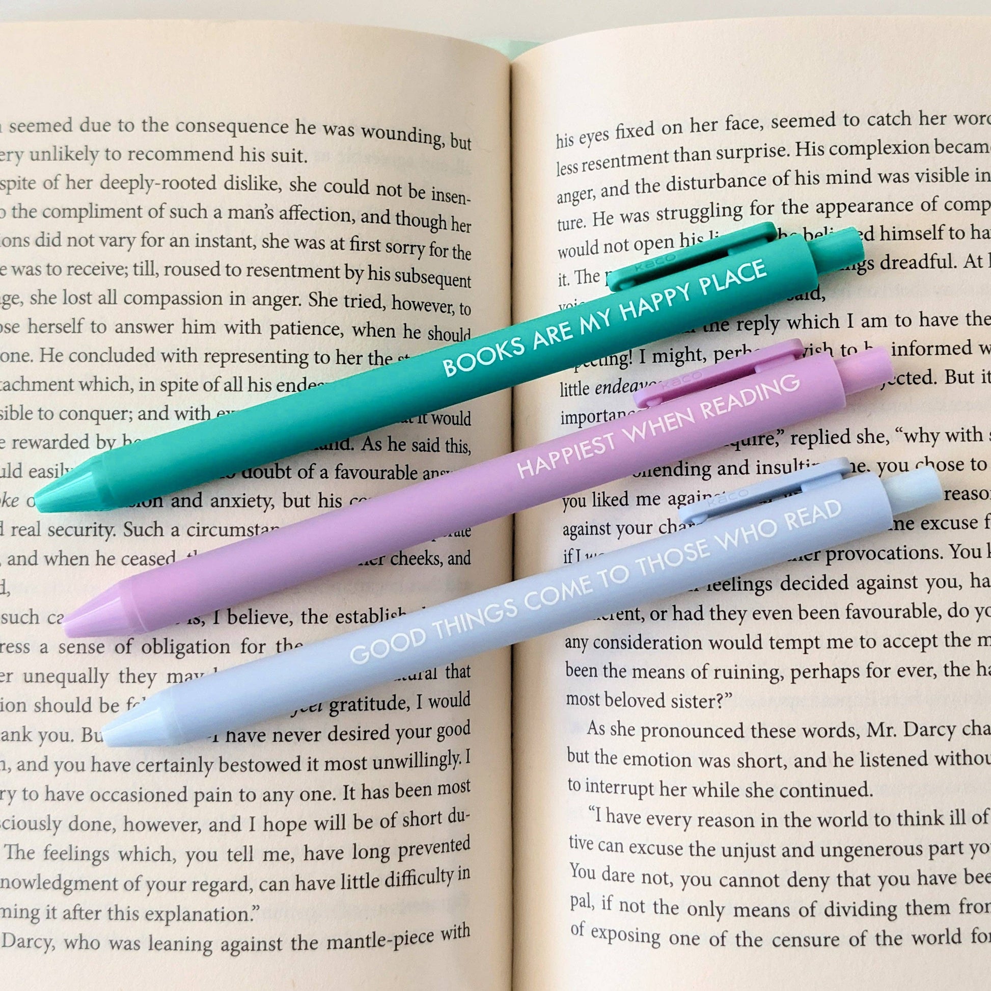 Three pens with motivational phrases on an open book
