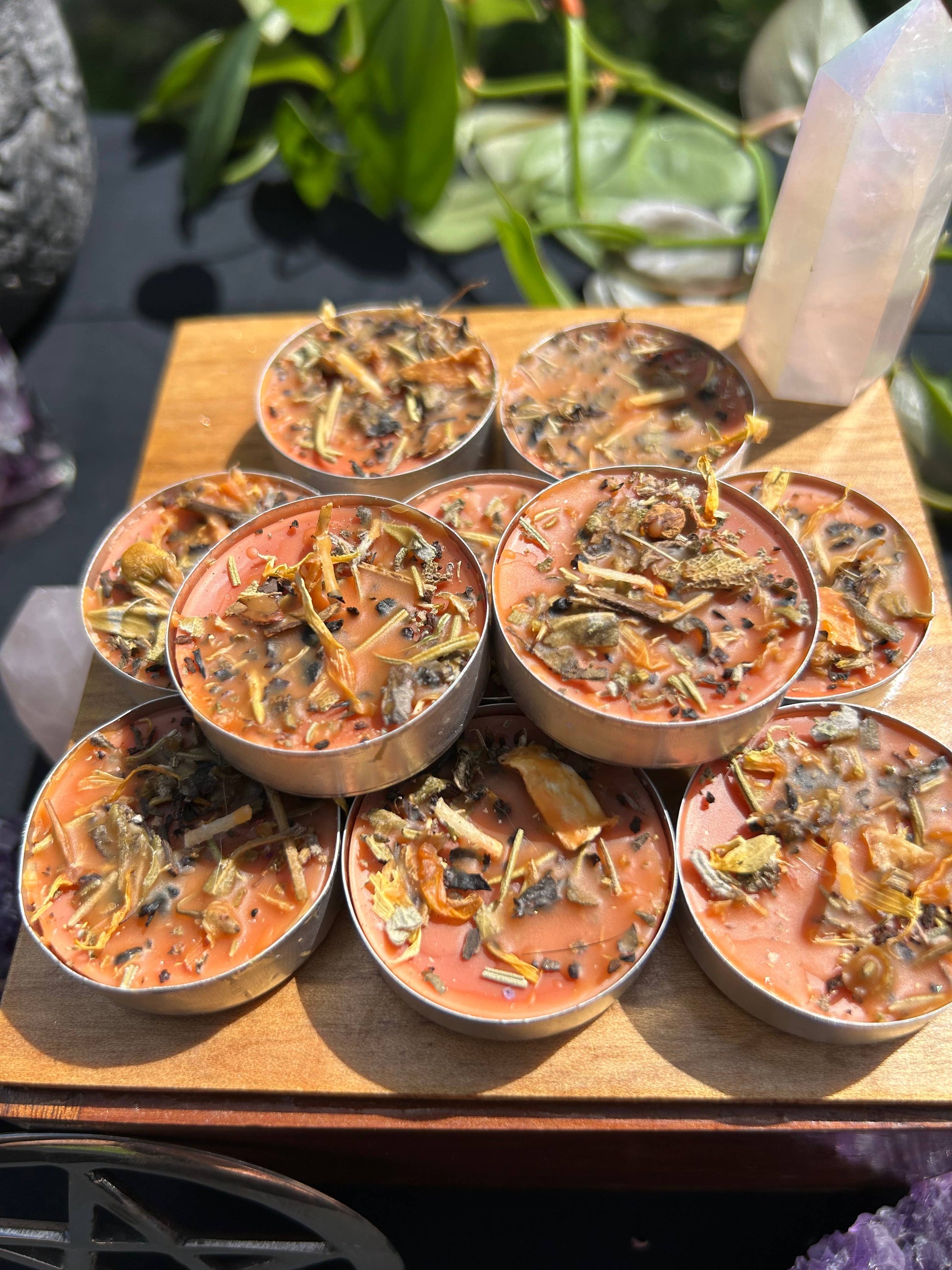 Small candles with herbs on a wooden surface.
