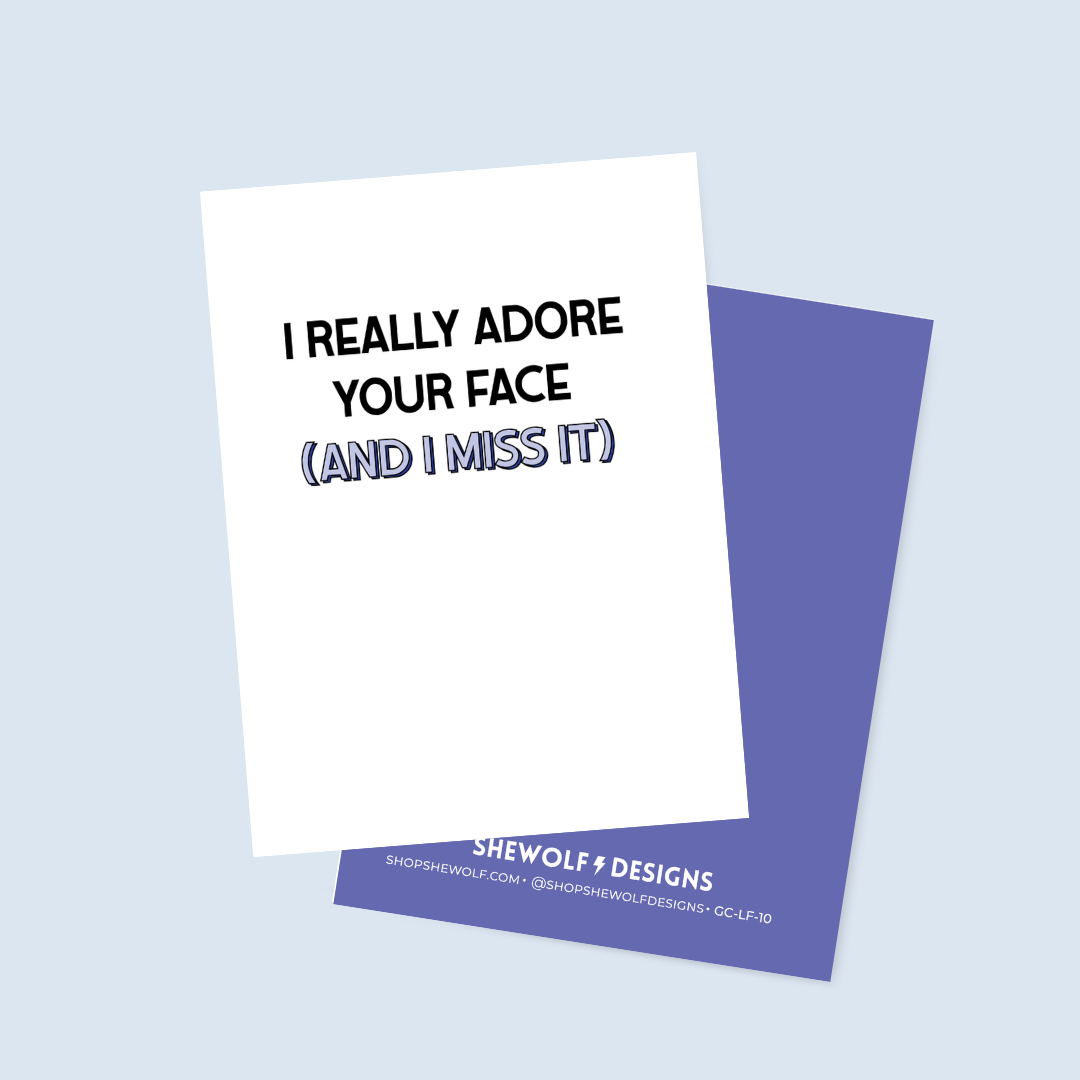 Greeting card with text 'I Really Adore Your Face (And I Miss It)' on a light blue background