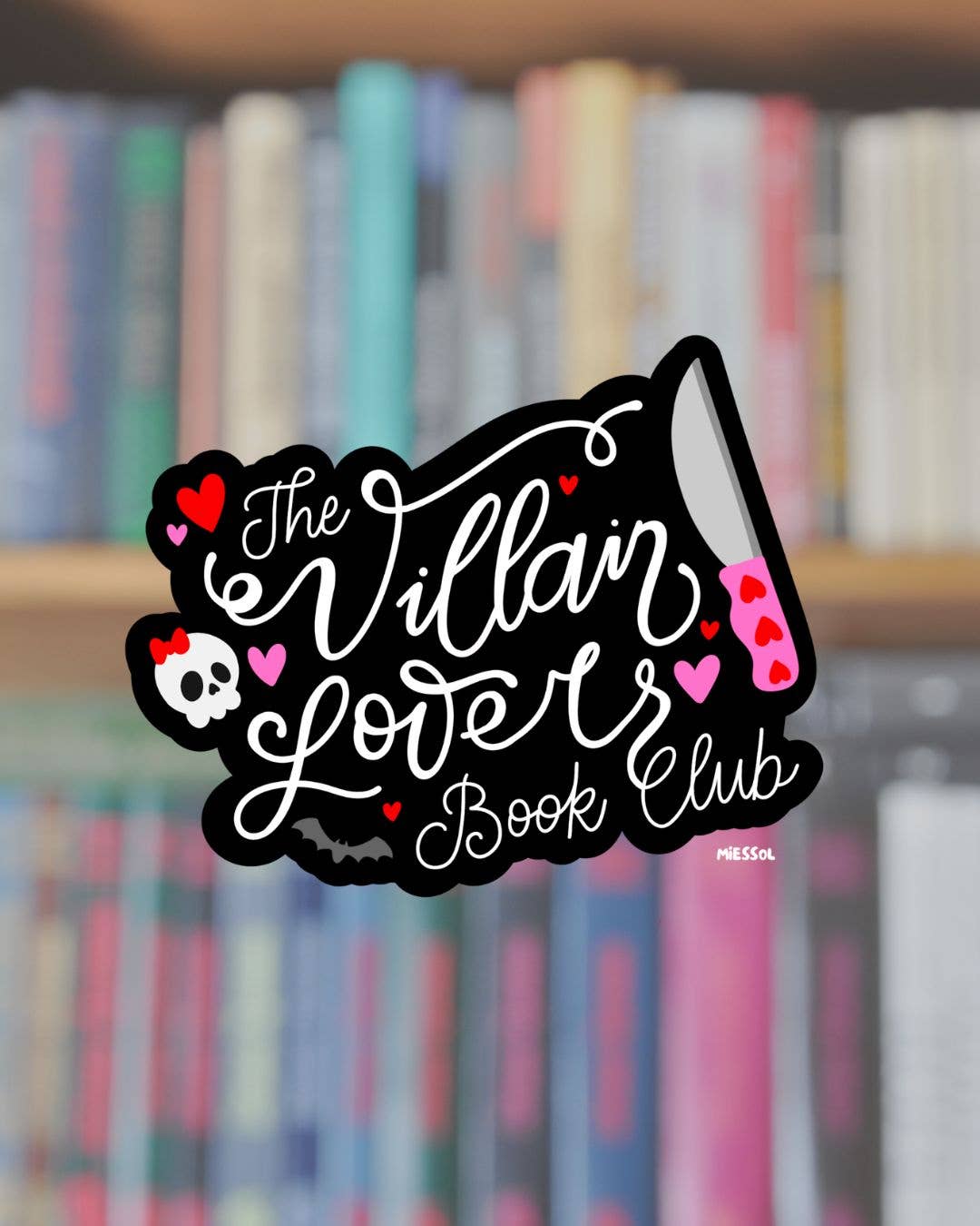 Sticker with 'The Villain Lover Book Club' design on a blurred bookshelf background